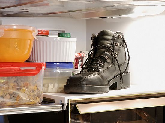 Schwarzer Schuh in einem Kühlschrankfach