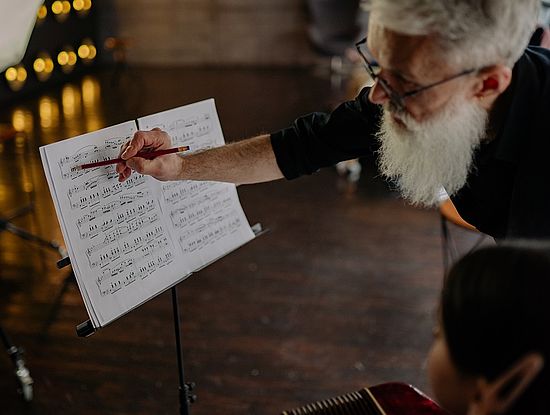 Älterer Mann gibt Musikunterricht