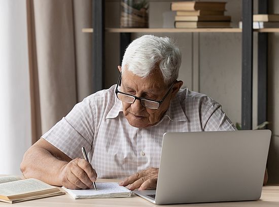 Älterer Mann beim Lernen mit Laptop