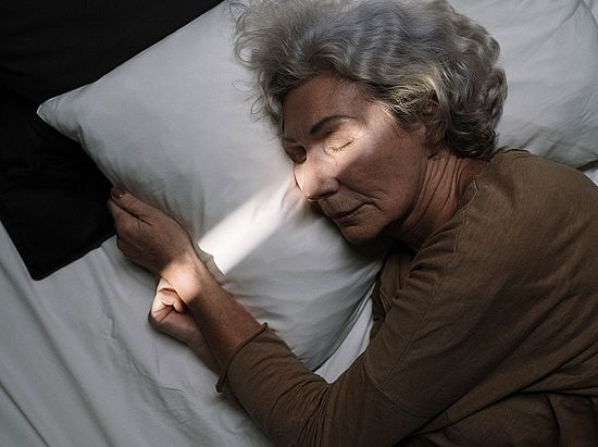 ältere Frau schläft im Dunklen