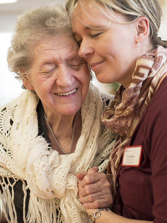 Hand in Hand: Foto von Alzheimer-Patientin und ihrer Betreuerin