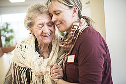 Foto aus dem Seniorenheim: Pflegerin umarmt Alzheimer-Patientin