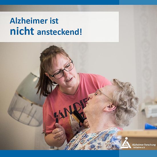 Bild mit Text: "Alzheimer ist nicht ansteckend" (Seniorin und Friseurin im Gespräch)