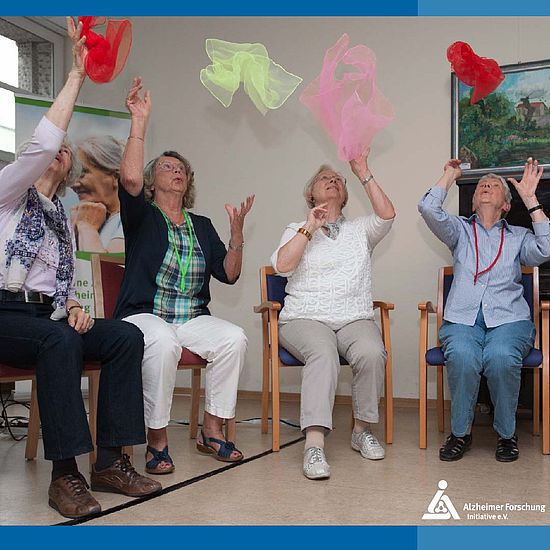 Seniorinnengruppe bei Bewegungsübung im Stuhlkreis