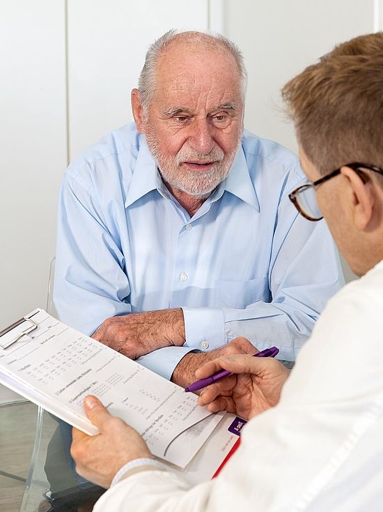 Arzt mit älterem Patient im Gespräch
