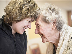 Seniorin und Angehörige lachen miteinander
