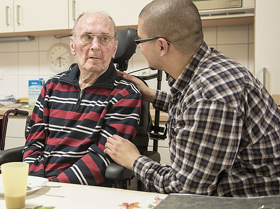 Pfleger im Gespräch mit Alzheimer-Patient