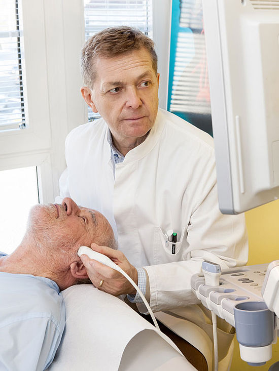 Arzt untersucht Patient mit Ultraschallgerät