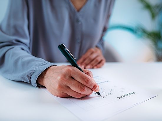 Person bearbeitet mit einem Stift einen MoCA-Testbogen.