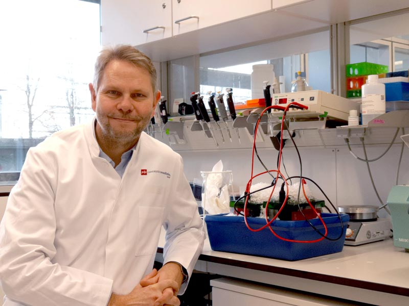 Prof. Dr. Claus Pietrzik im Labor sitzend